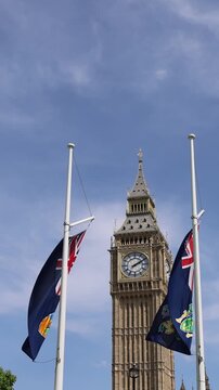 London, Tower of Big Ben on Parliament Square with flags waving in front of it, Great Bell of Clock