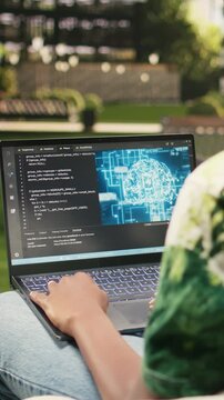 Vertical video: The student uses binary code and AI on a laptop, programming language with machine learning and neural networks, during solo study on a modern campus, reflecting student life.