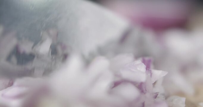 Tabletop Macro Close up of kitchen knife chopping onions in slow motion