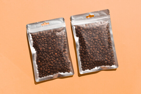 Blank craft plastic pouch mock up with coffee beans inside, transparent pack on studio background with shadow, mylar bag isolated for coffee product