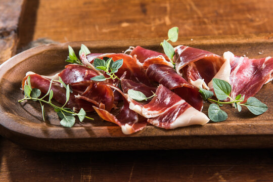 Italian prosciutto crudo or jamon with rosemary. Raw ham appetizer