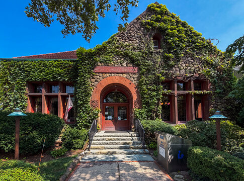 Nyack, NY - US - Aug 9, 2026 Ivy-covered stone facade of Nyack Public Library with arched red sandstone entrance, lush greenery, and bright blue sky, highlighting historic charm in Nyack, NY.