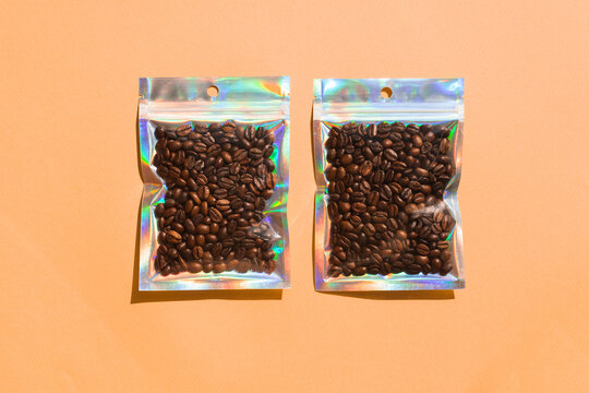 Blank craft plastic pouch mock up with coffee beans inside, transparent pack on studio background with shadow, mylar bag isolated for coffee product