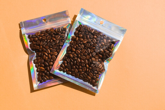 Blank craft plastic pouch mock up with coffee beans inside, transparent pack on studio background with shadow, mylar bag isolated for coffee product