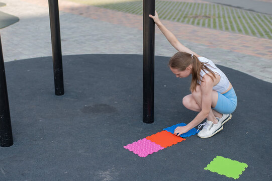 A woman with cerebral palsy walks on sensory mats. Rehabilitation