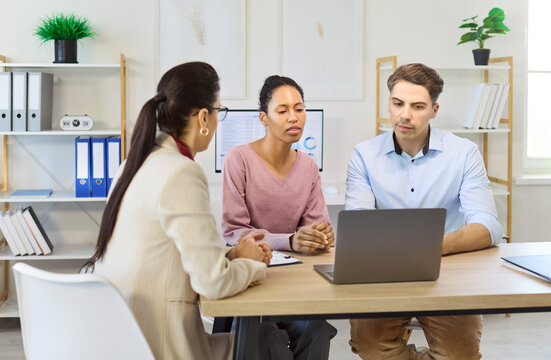 Couple and advisor in finance consultation discussion. They review mortgage options, loan terms and planning to reach agreement through discussion. Concept of financial guidance and trust.