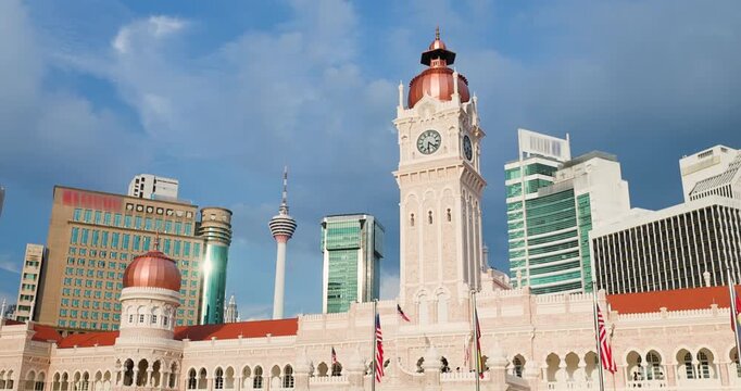 Majestic Sultan Abdul Samad Building with its iconic clock tower in Kuala Lumpur, Malaysia, set against a backdrop of modern skyscrapers and the towering KL Tower.