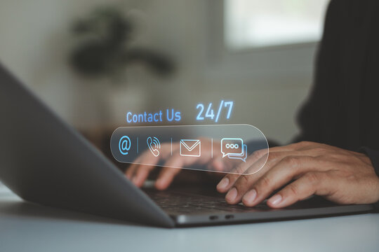 Customer service concept. Businessman using a laptop with contact icons for email, phone and chat, representing 24/7 support, communication, online assistance and business service.
