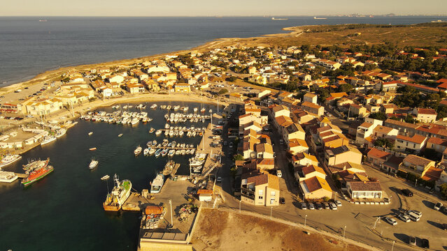 Aerial view of the Carro harbor with numerous boats docked in the marina, surrounded by coastal buildings and Mediterranean landscape in Martigues, Provence-Alpes-Cote d'Azur, France.