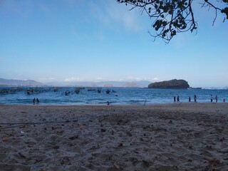 Tranquil Tropical Beach with Mountain and Island Background © choirul