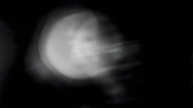Abstract motion blurred glowing light orb moving across dark space background with abstract background movement luminescent atmosphere