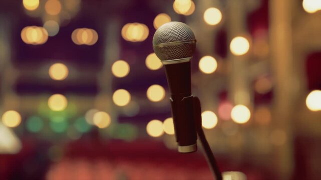 Retro microphone on dimly lit cabaret stage, smoky warm atmosphere and blurred audience seats, awaiting vocalist for intimate jazz set or late night