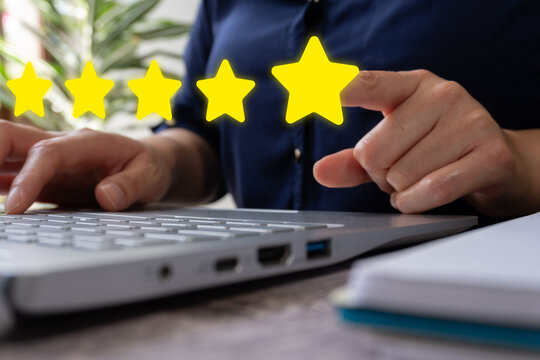 Close-up of hand clicking star rating on digital device