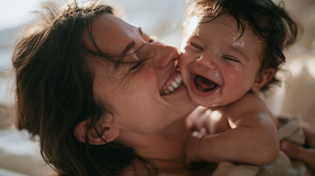 Happy Mother Laughing and Cuddling with Her Baby