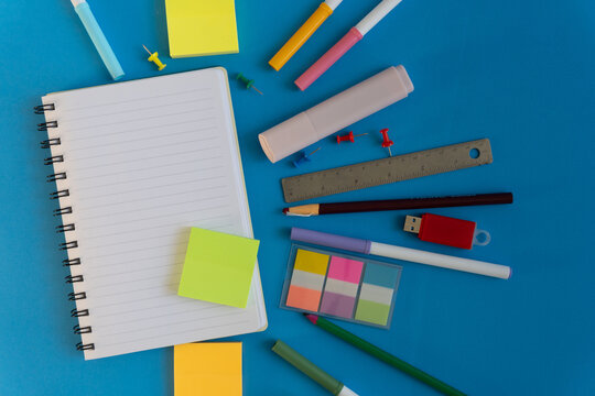 Assorted stationery tools on bright blue surface