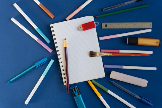 Creative stationery layout with writing instruments on blue background