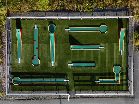 Aerial view of a miniature golf course with green artificial turf and various obstacles in Kempele, Pohjois-Pohjanmaa, Finland.