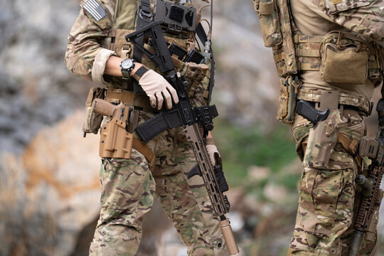 Military soldier is carrying rifle gun during field operation in dangerous battlefield for peace and conflict resolution concept