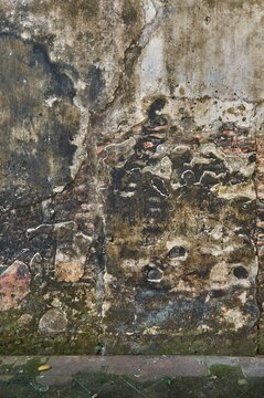 Old brick wall texture with weathered plaster and dampness