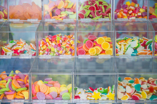 Vibrant variety of colorful jelly candies and gummies showcased in clear acrylic bins. This eye-catching display is perfect for candy shop themes, desserts, and sweet snack concepts.