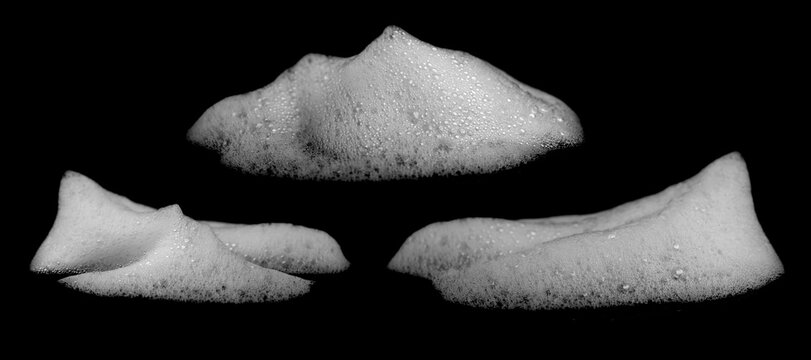 Abstract white foam with tiny bubbles forms soft organic shapes on a black background, creating dramatic monochrome contrast, detailed texture and a clean modern visual for creative design.