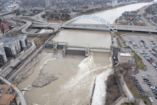 Aerial view of the Genesee River flowing over the Court Street Dam with the Frederick Douglass-Susan B. Anthony Memorial Bridge and urban infrastructure in Rochester, New York, United States.