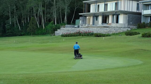 Golf Course Maintenance Worker Mowing Lawn in the Early Morning, 4K 50fps