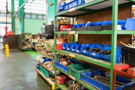 Industrial storage shelves with spare parts in factory warehouse, Metal racks with plastic bin and components in manufacturing plant, Workshop shelf with mechanical tools and hardware parts in factory