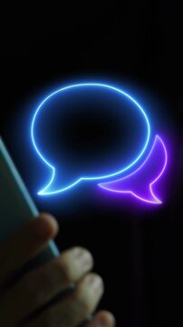 Businessman holding smartphone vertical shot displaying glowing double speech bubbles message frame mockup overlay display. Social media chat conversation, testimonial dialog, and feedback concept.