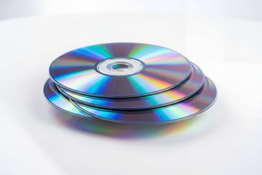 Stack of Compact Discs on a White Surface with Reflection