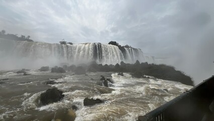 Majestic Iguazu Falls in Brazil with powerful cascades and turbulent waters under a cloudy sky © Felippe Lopes