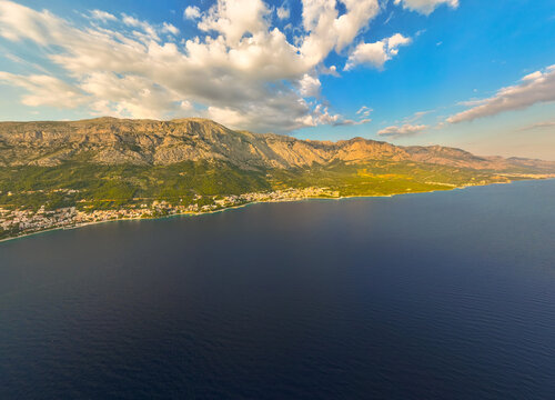 Aerial view of the coastal town of Brela nestled between the Biokovo mountains and the Adriatic Sea, Brela, Split-Dalmatia County, Croatia.