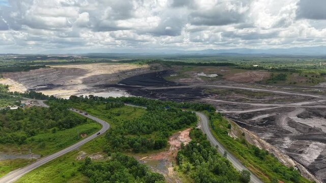 Aerial view of a coal mining site right next to a highway with deep excavations resulting from mining operations