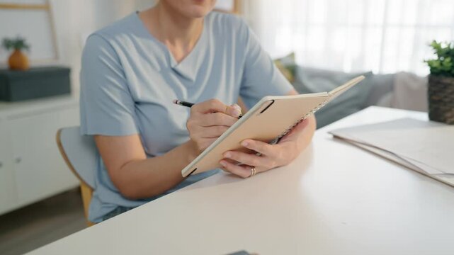 Caucasian female artist painting artwork on canvas frame at home studio.
