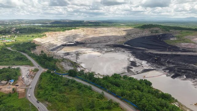 Aerial view of a coal mining site right next to a highway with deep excavations resulting from mining operations