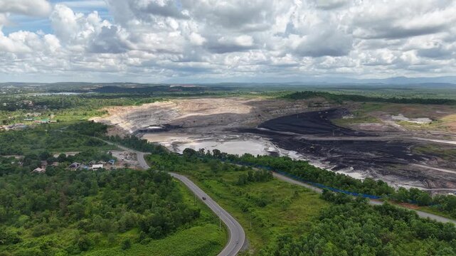 Aerial view of a coal mining site right next to a highway with deep excavations resulting from mining operations