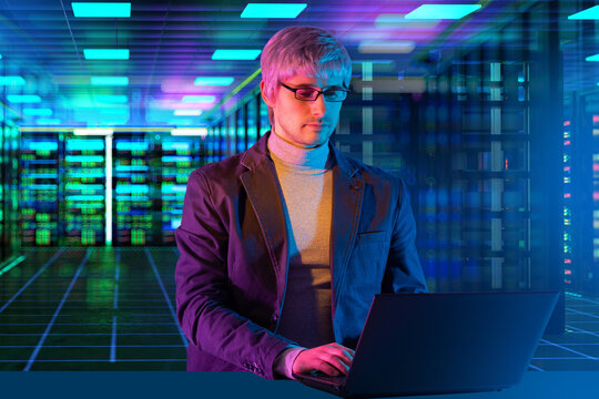Data center operations. IT specialist manages server infrastructure using laptop during network administration, cybersecurity monitoring and cloud computing support.