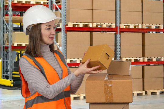 Warehouse operations. Logistics employee inspects packaged goods and prepares shipments during inventory control, order fulfillment and distribution center activities.