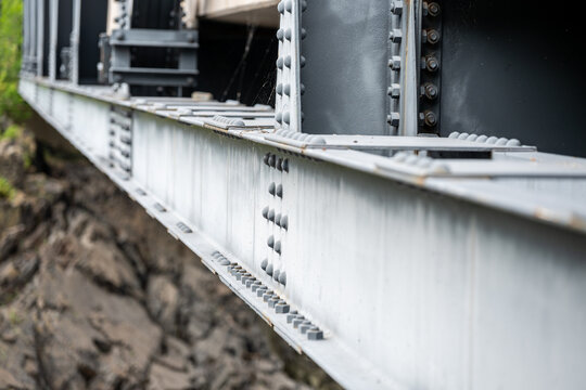 close-up of structural steel girders and bolted riveted joints on a metal bridge framework. industrial engineering or strength and resilience themes.