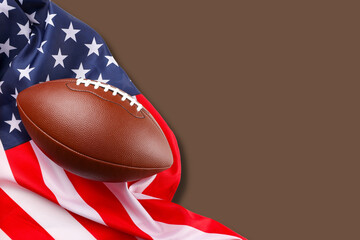 Fototapeta premium Classic American football rests against a vibrant flag