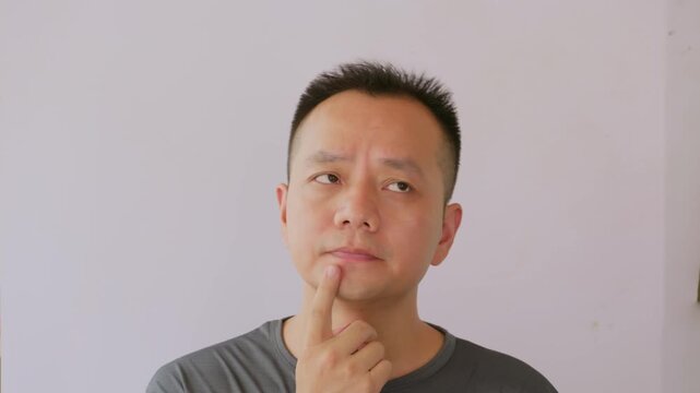 Thinking idea and Asian man in studio with question doubt or decision for career development choice. Man thinking quesiton.