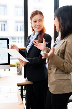 Asian Business Women Standing and Talking During Work Meeting in Modern Office