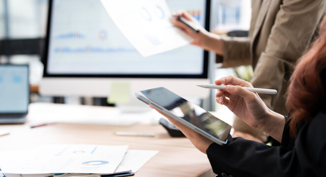 Asian Business Women Using Digital Tablet with Stylus Pen for Financial Analysis in Office