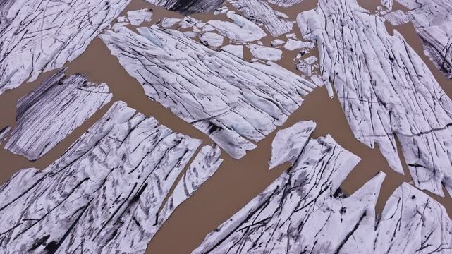 Brown water and ice formations at Hoffelsj&ouml;kull glacier in Iceland, aerial