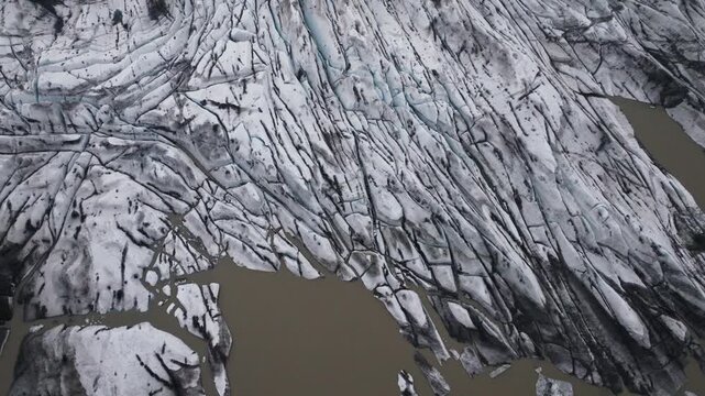 Glacial landscape with volcanic ash and colored water in Iceland, aerial