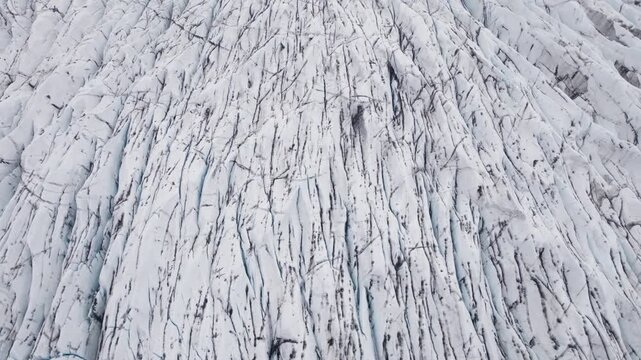 Slow aerial pan along ice formations in old glacier in Iceland