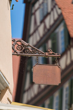 leeres Schild mit Platz f&uuml;r eigenen Text an der Fassade eines Hauses in einer deutschen Altstadt