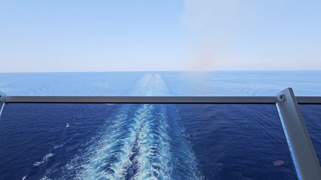 Static stern view of a cruise ship wake stretching far across calm open sea