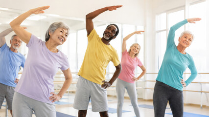 Fototapeta premium Happy seniors exercising together in fitness class