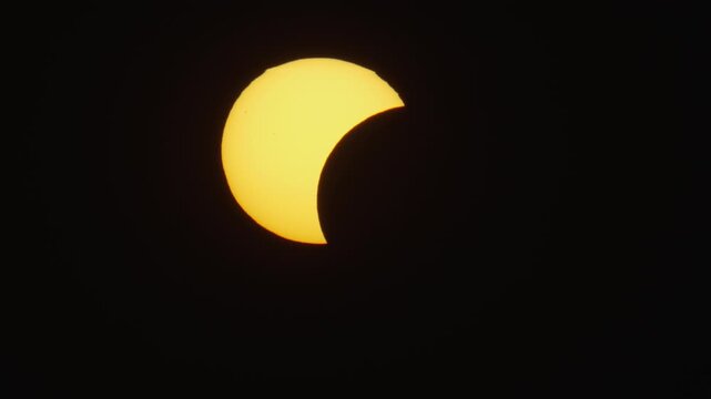 Aerial view of a partial solar eclipse with the moon obscuring part of the sun against a dark sky in Krakow, Lesser Poland Voivode, Poland.